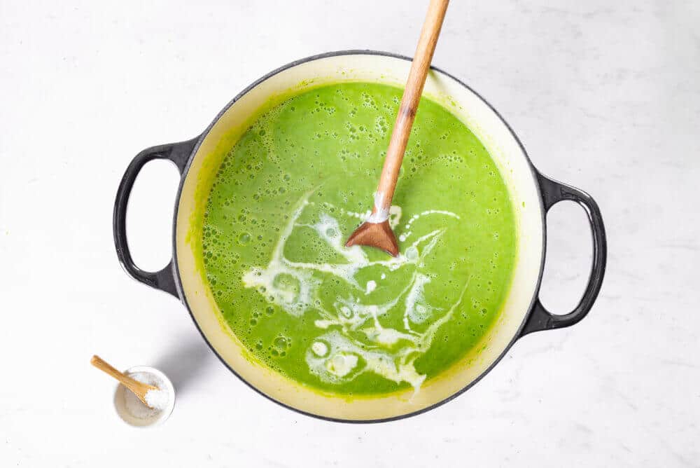 pea-soup-cooking-in-a-soup-pot-with-a-wooden-spoon-and-a-small-bowl-of-salt-on-the-side