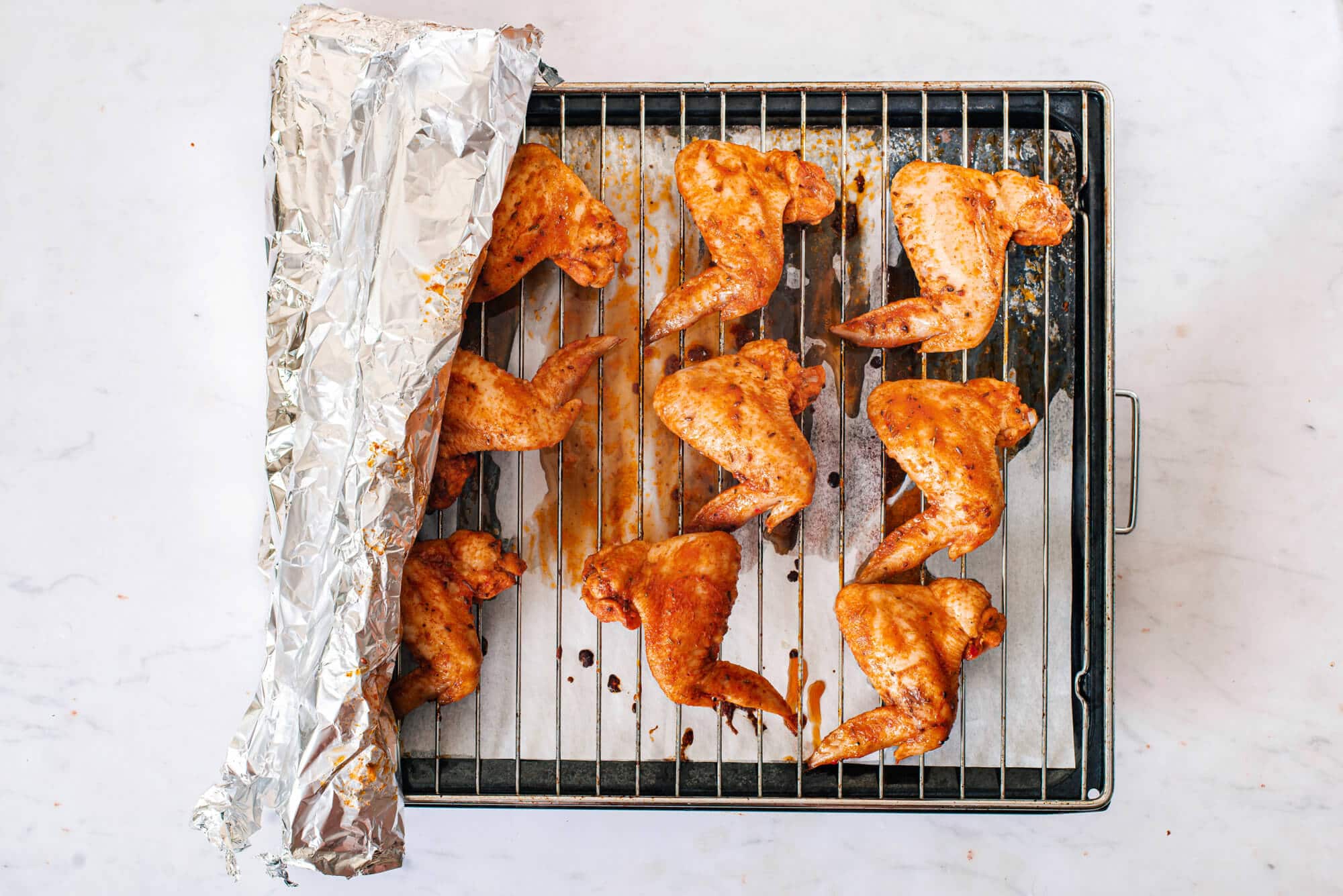 raw-chicken-wings-on-a-wire-rack-on-a-baking-tray-with-tinfoil-on-the-side