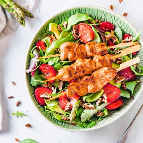 chicken-skewer-salad-in-a-green-bowl-with-a-fork-on-the-side-with-asparagus-stalks-on-a-towel