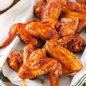 chicken-wings-on-parchment-paper-tray-on-a-striped-towel-with-arugula-on-the-side