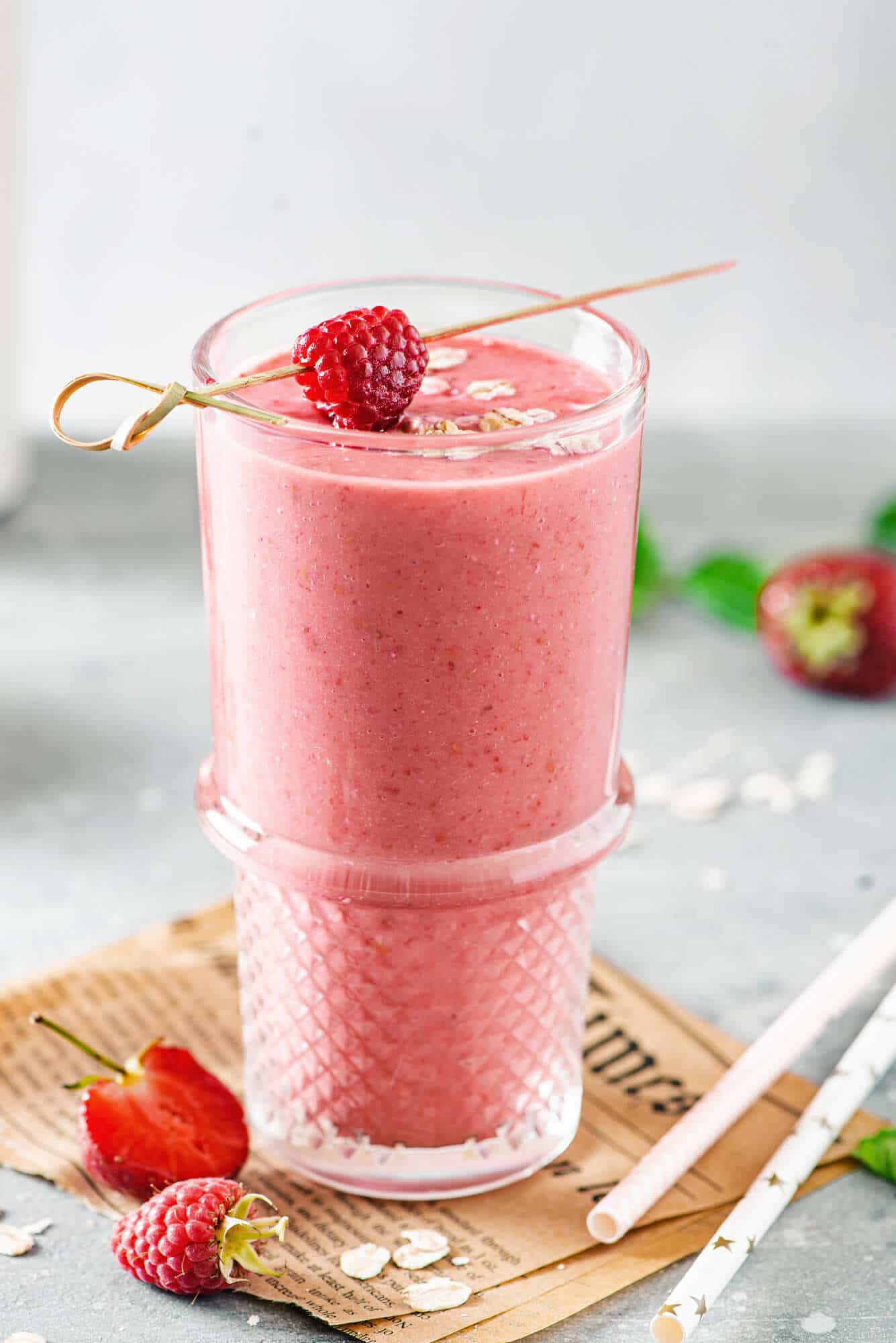 berry-smoothie-in-a-glass-with-raspberries-and-strawberries-around-and-straws