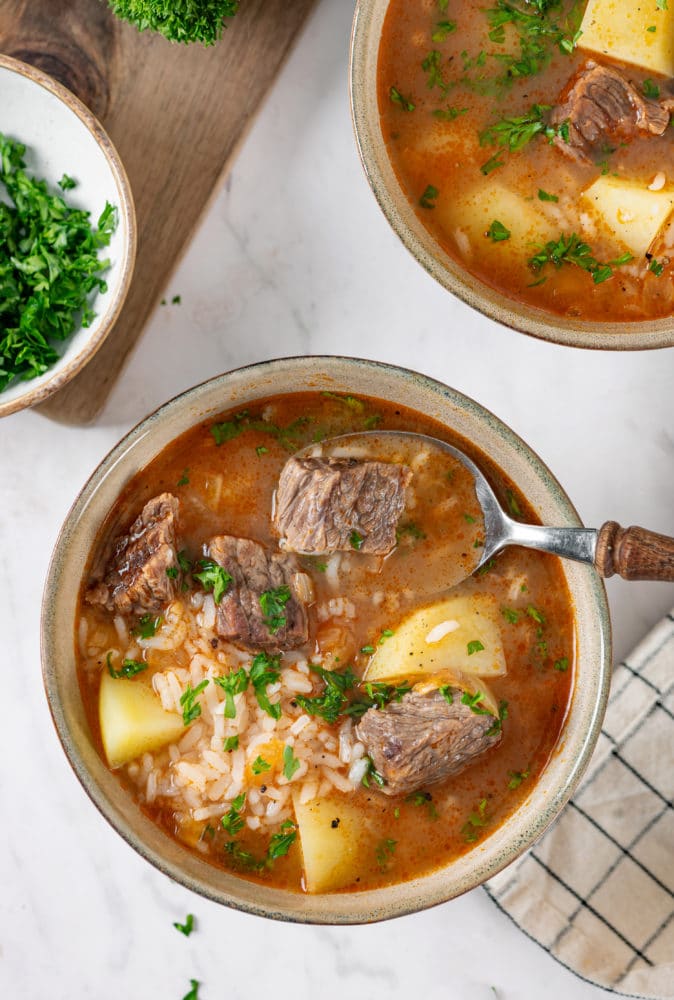 beef-soup-in-a-beige-bowl-with-a-spoon