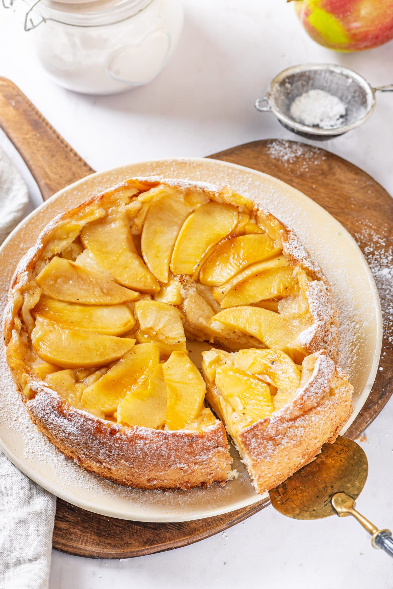 apple sharlotka recipe cake baked and put on a plate with sifted powdered sugar. 