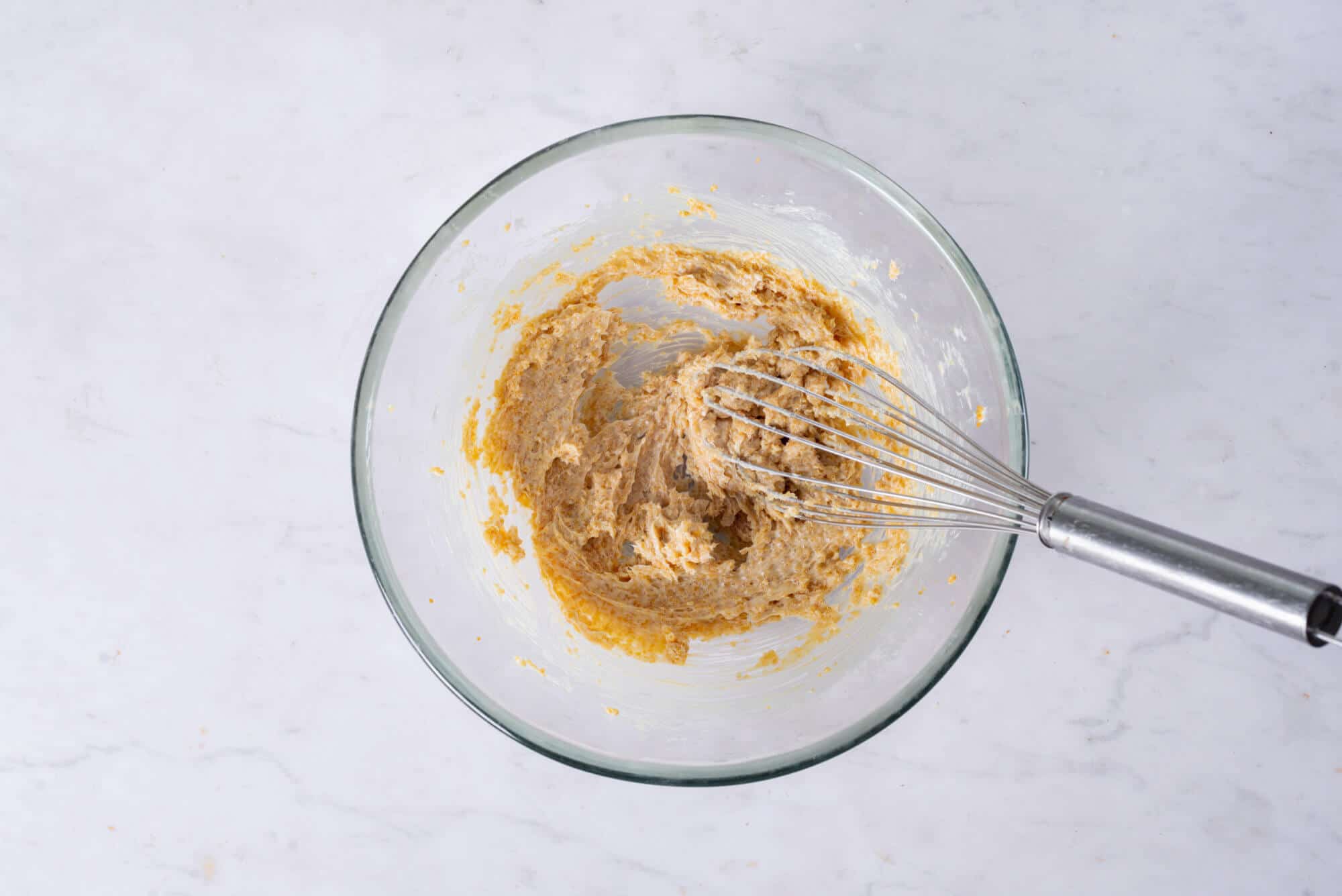 plum-cake-batter-in-a-clear-bowl-with-a-whisk