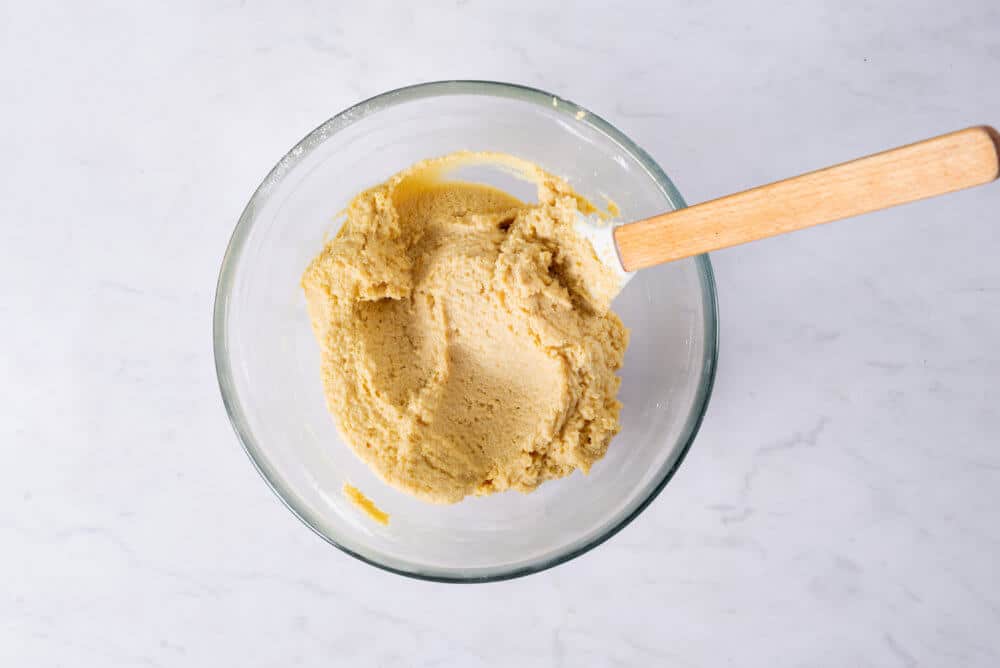 cake batter in a bowl with a spatula.