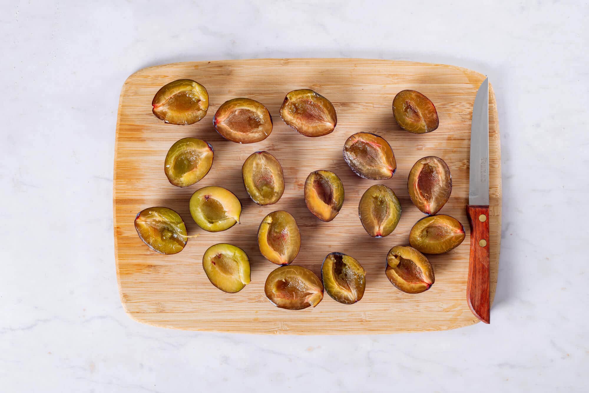 plums-sliced-on-a-wooden-board-with-a-knife