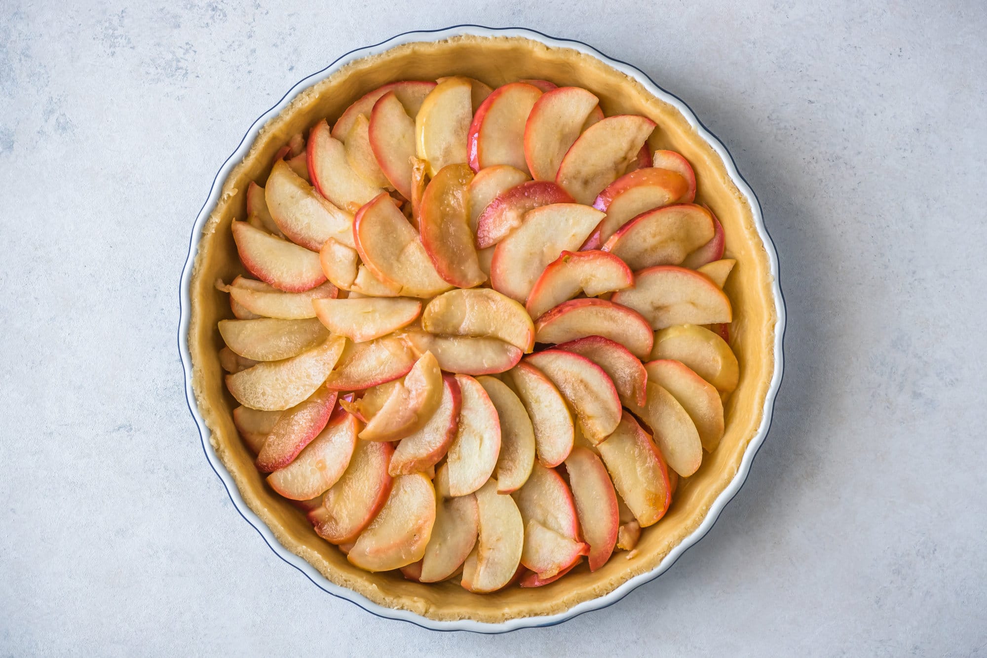 Unbaked apple tart in a baking tray. 