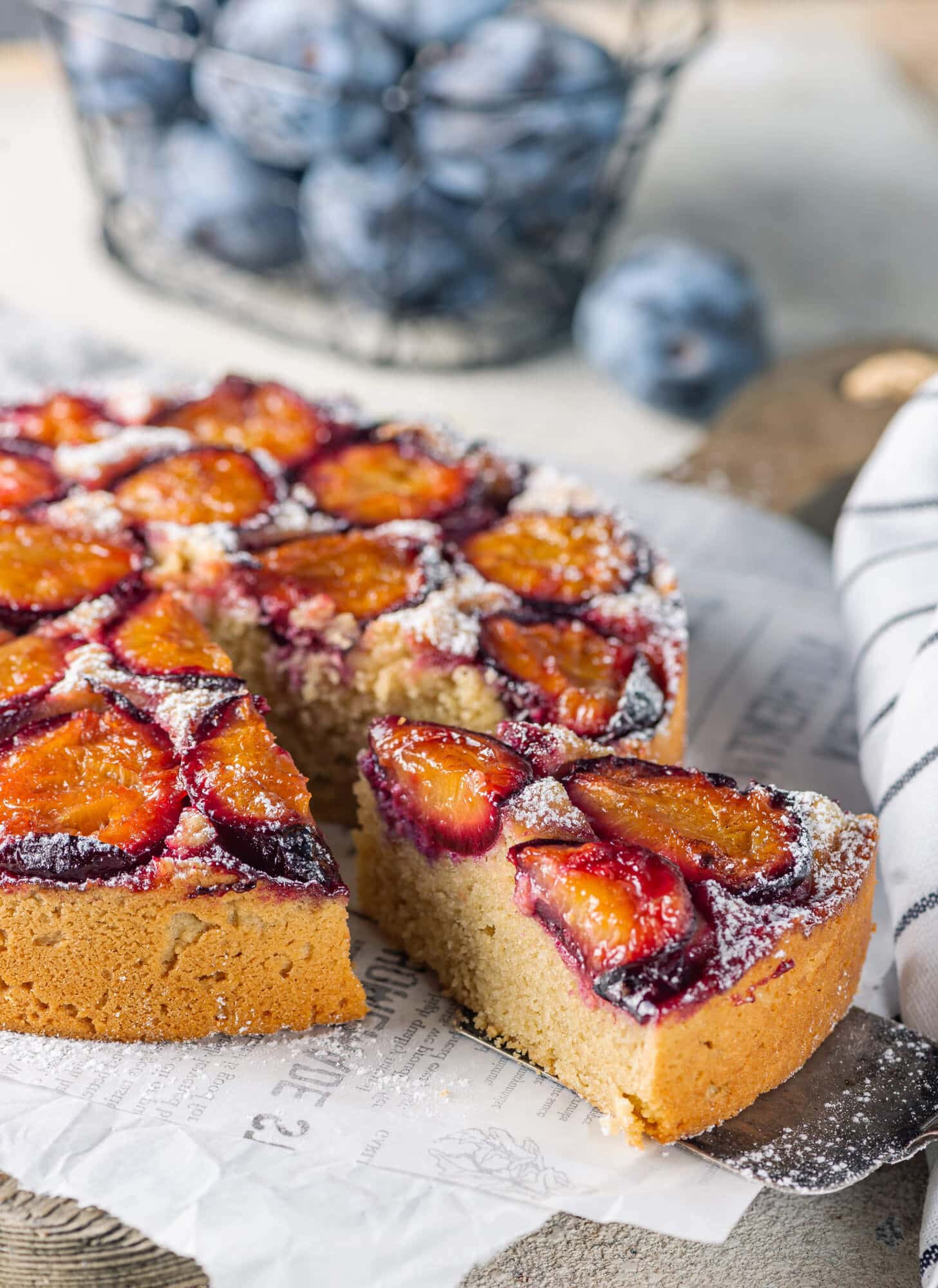 plum-cake-on-white-paper-on-a-wooden-board