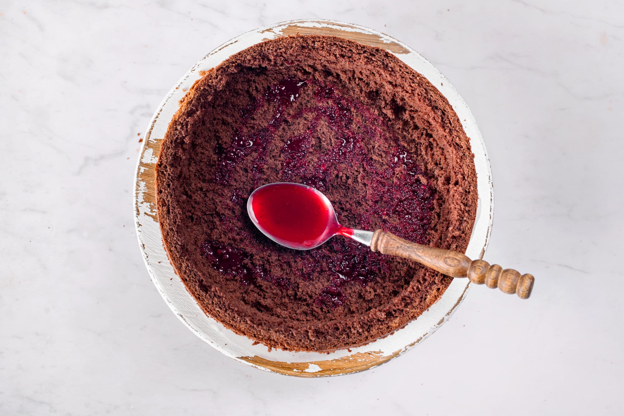 cherry-chocolate-cake-being-put-together-with-a-spoon