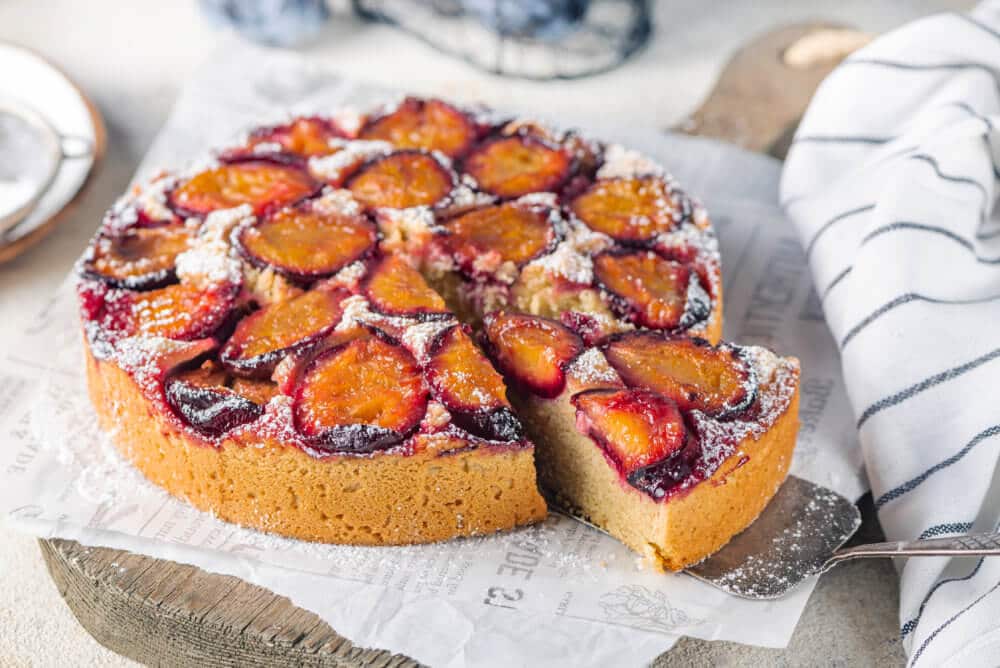 plum cake on a board with white paper.