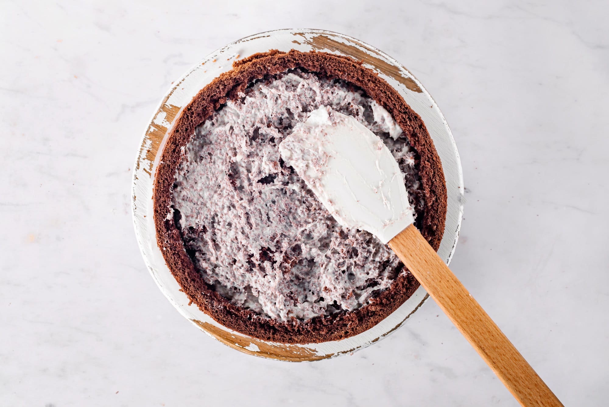 cherry-chocolate-cake-being-put-together-with-a-spatula