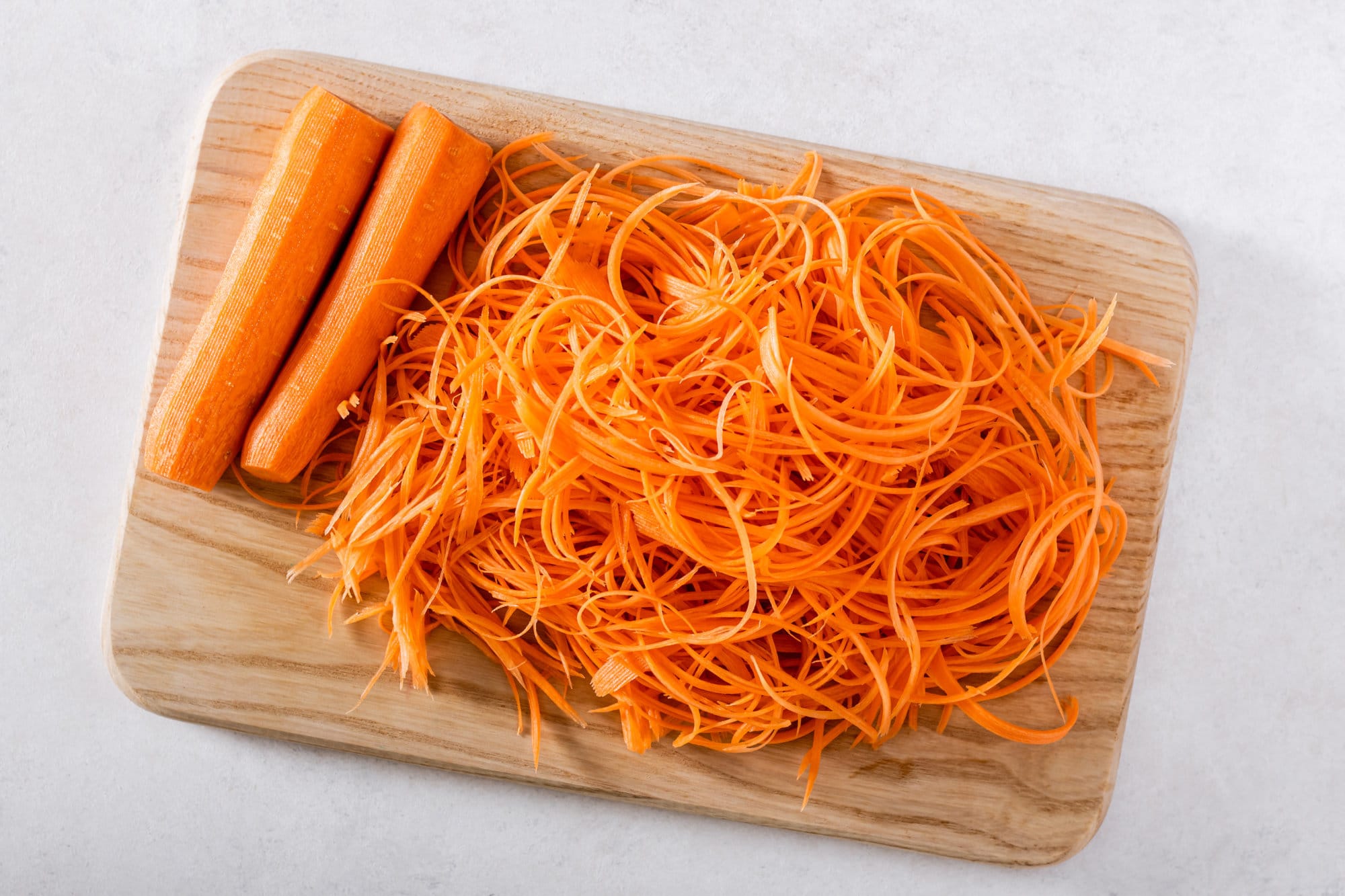 shredded-carrots-on-a-wooden-cutting-board