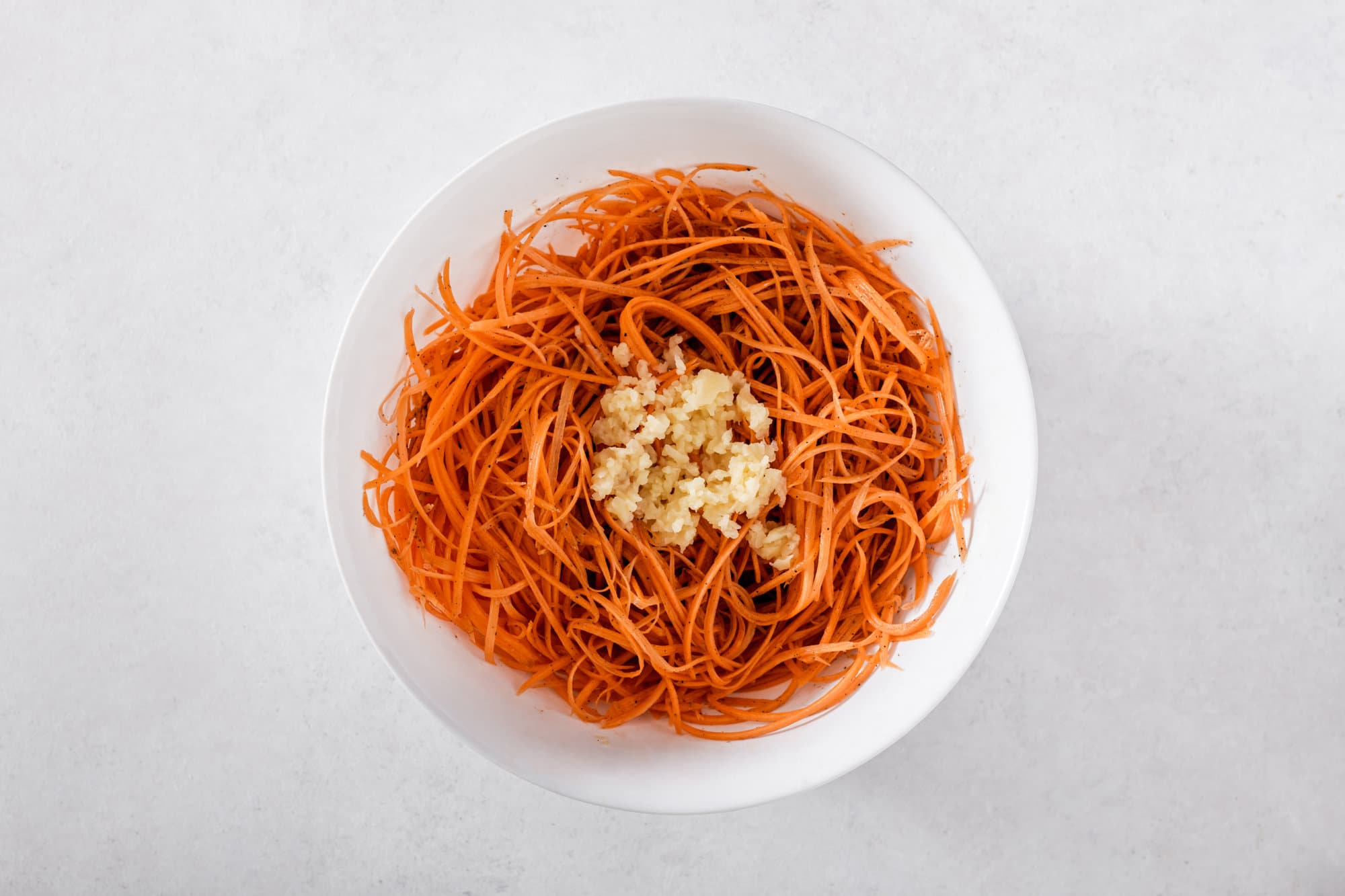 carrot-salad-in-a-white-bowl-with-minced-garlic