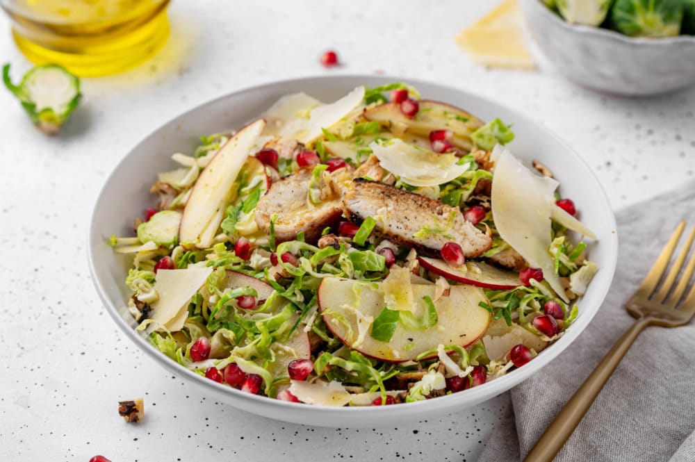 A bowl of sprouts salad with toppings.