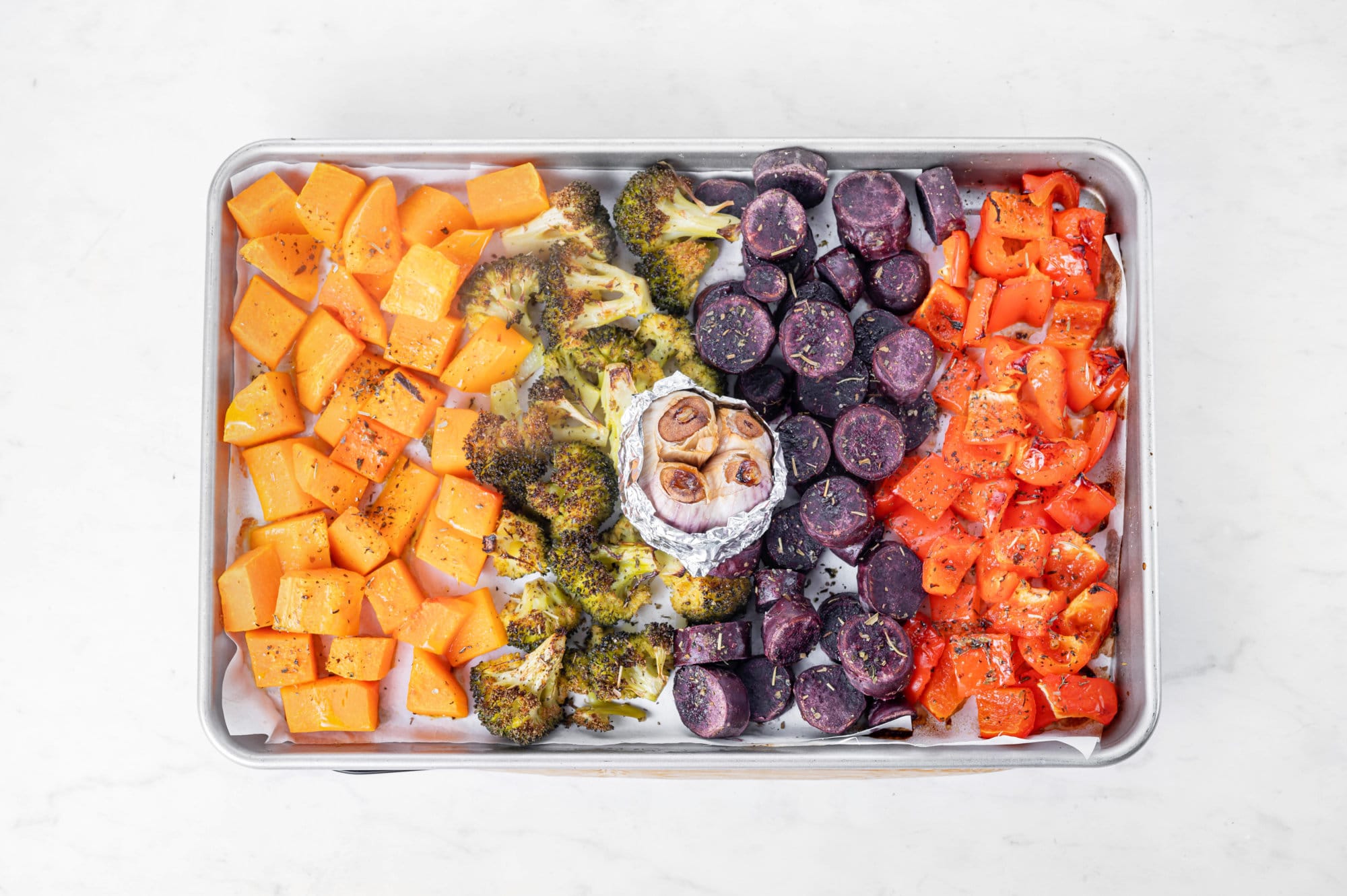 Roasted Vegetables in the Oven with Easy Roasted Garlic Lemon Dressing veggies all roasted fresh out of the oven on a baking tray with garlic.