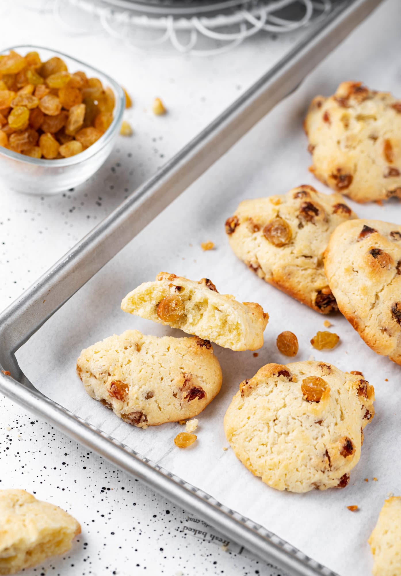 Fresh baked golden raisin cookies on a baking tray.