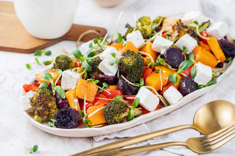 roasted-vegetables-on-white-plate-with-gold-fork-and-spoon