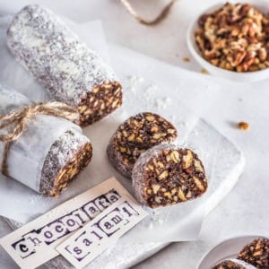 Chocolate salami slices on a white board with paper labels.