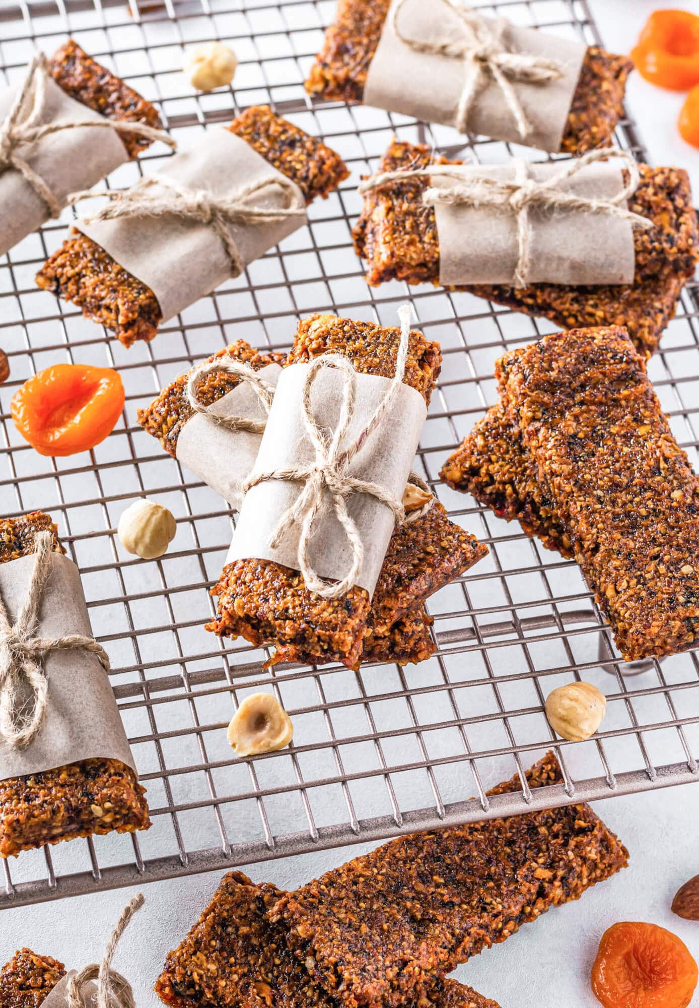 Gluten-Free Dried Fruit Bars with Nuts and Dates on The Go Dried fruit and nut bars atop a wire rack, wrapped in parchment and twine.