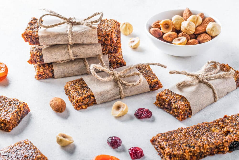 dried-nut-fruit-bars-wrapped-in-brown-paper--and-twine-with-dried-nuts-and-fruits-around