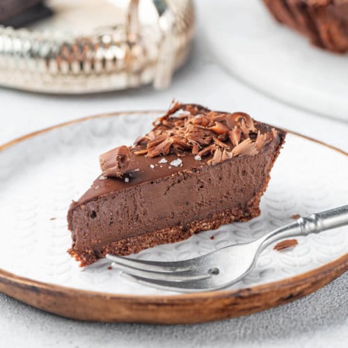 a decorated slice of the chocolate tart on a plate with a fork.