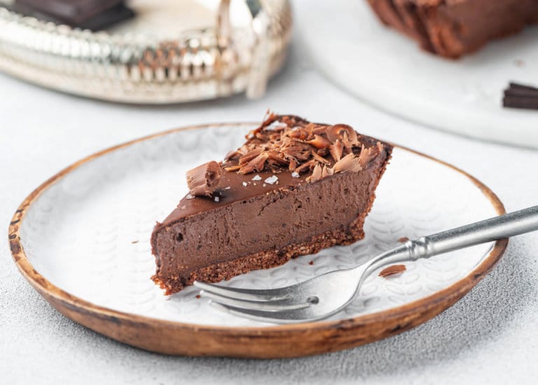 a decorated slice of the chocolate tart on a plate with a fork.