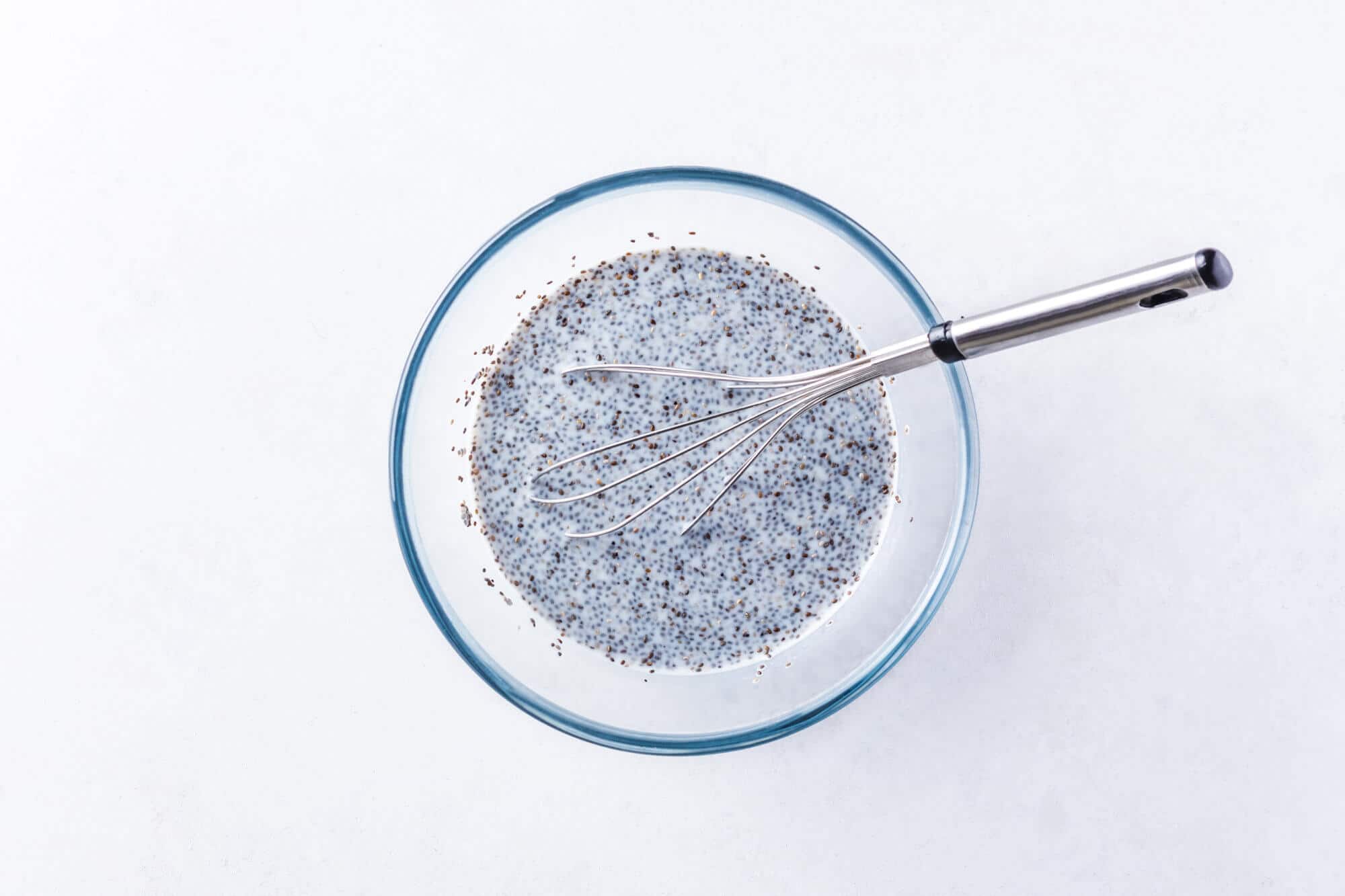 chia-seeds-with-almond-milk-in-clear-bowl-with-whisk