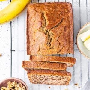 sliced-banana-bread-on-wire-rack-with-ingredients-and-knife
