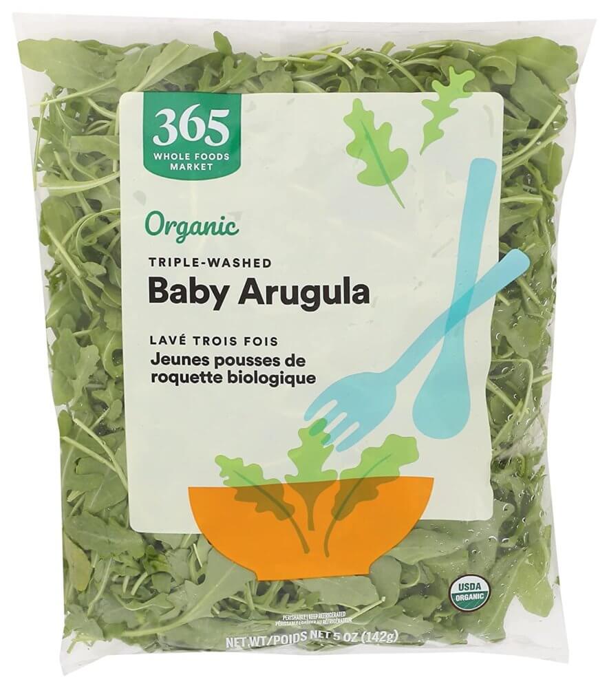 a bag of 365 brand baby arugula on a white background
