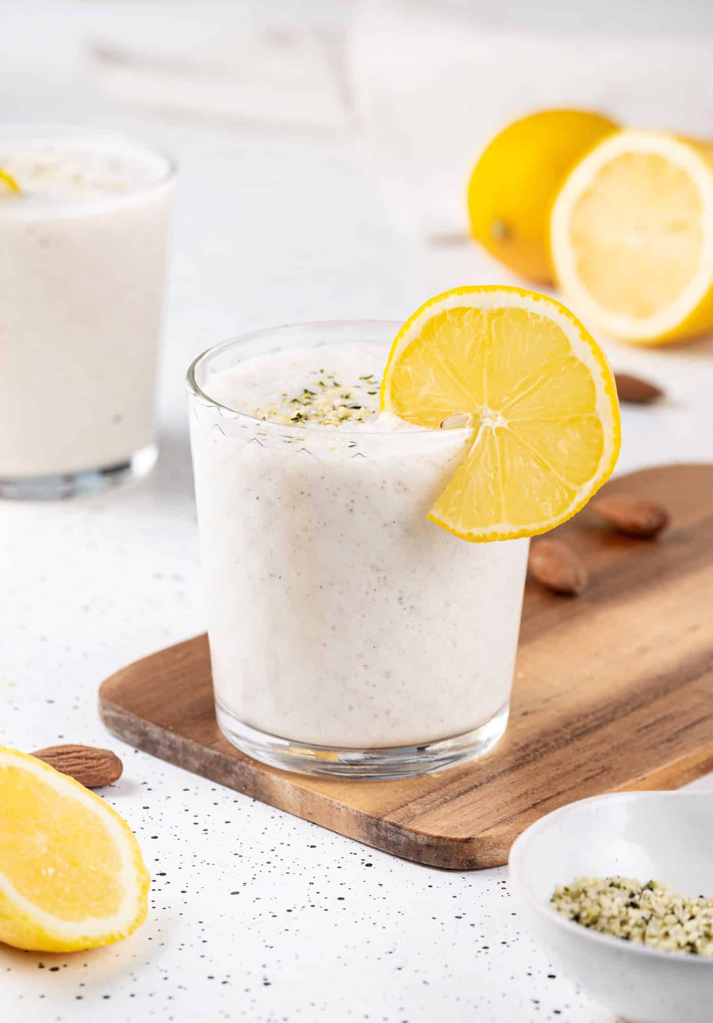 hemp seeds sprinkled atop a smoothie with a lemon wedge on the rim.