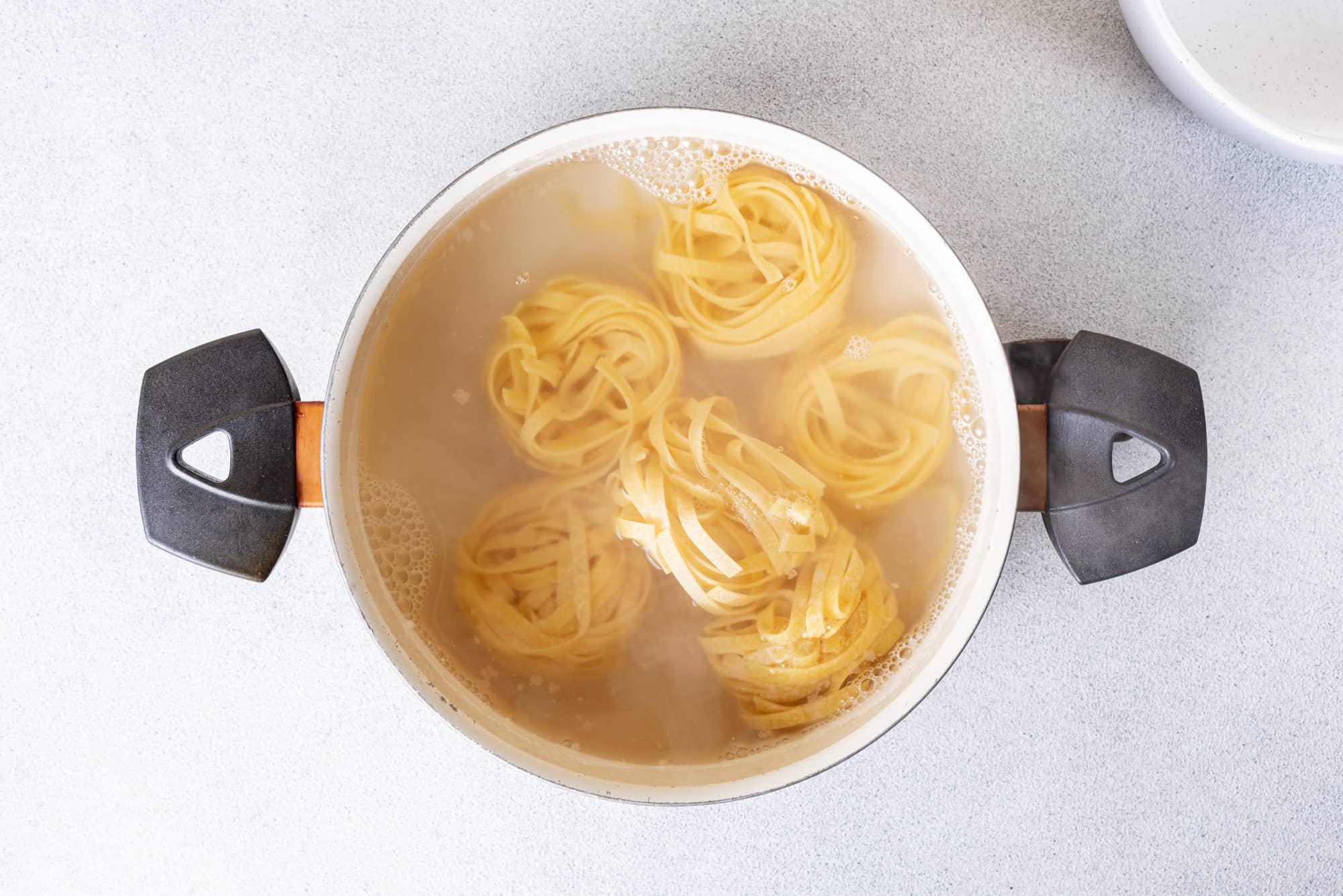 Pasta cooking in a pot of boiling water.