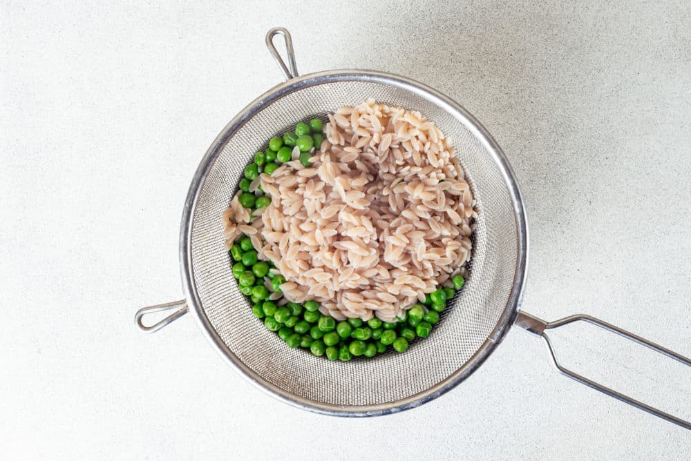 drained-orzo-and-peas-in-a-sieve