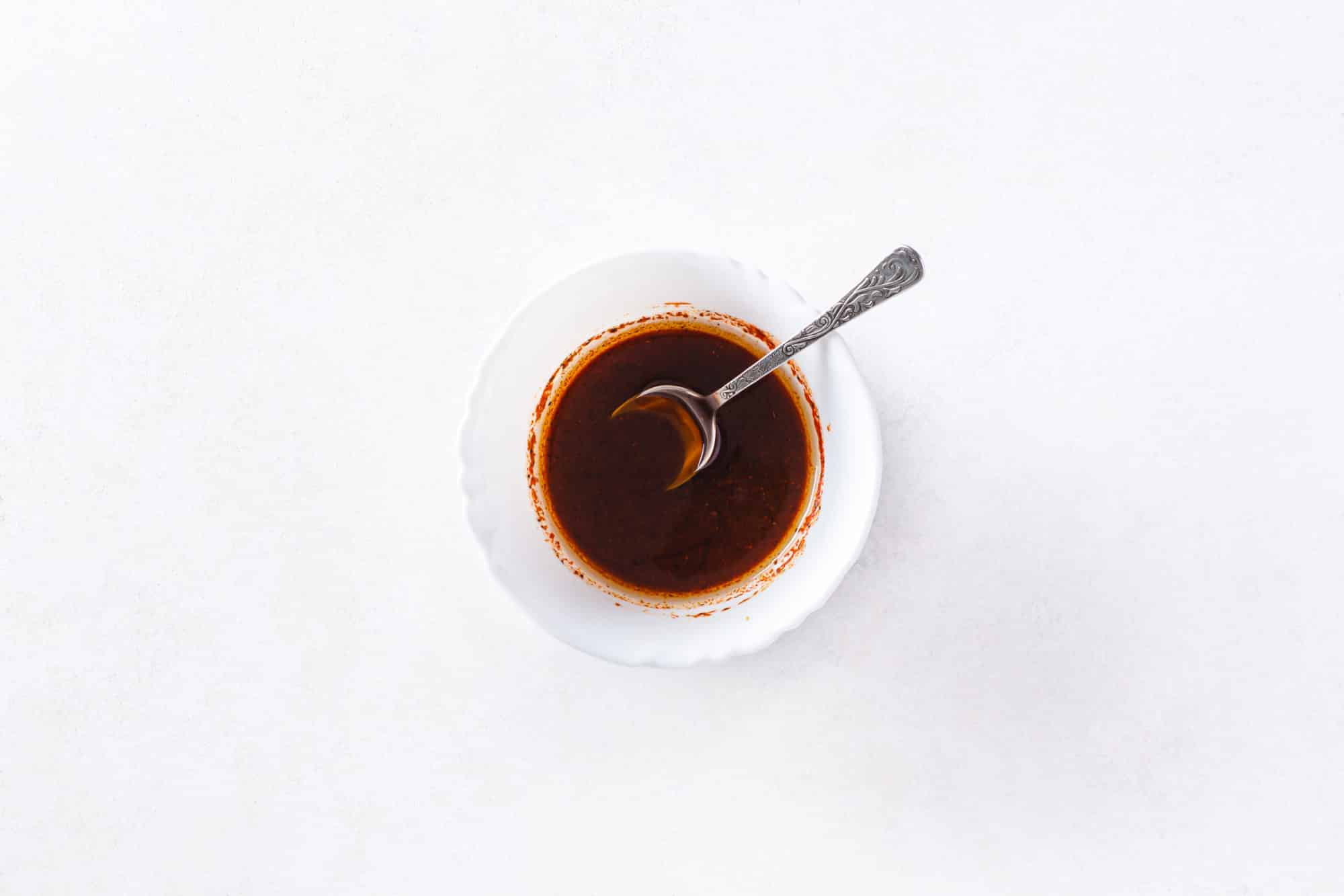 Soy sauce mix for tofu in a white bowl with a spoon.