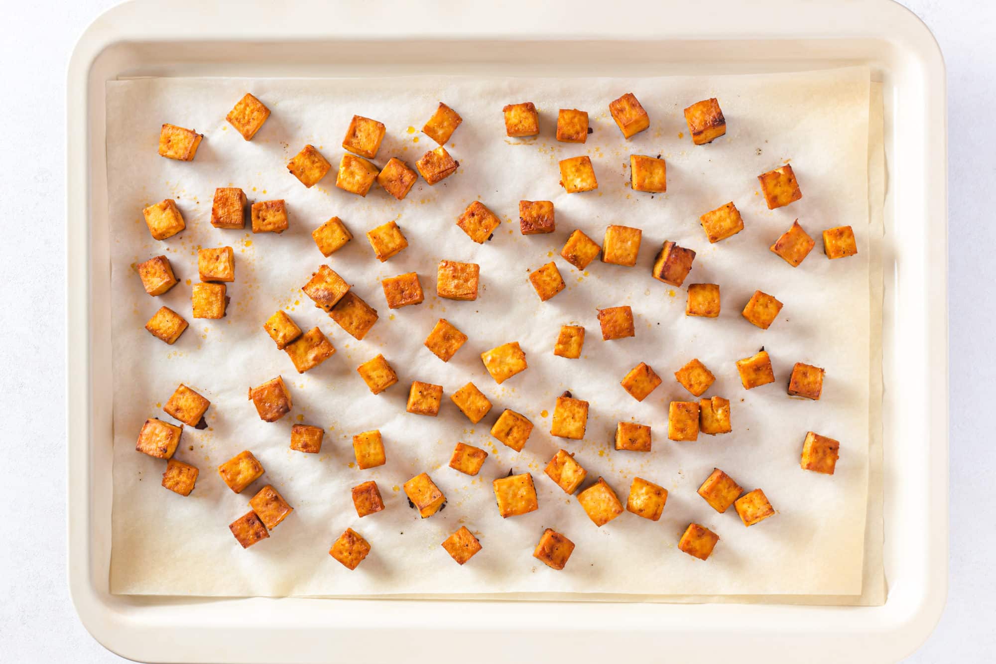 Crispy baked tofu on a baking tray.