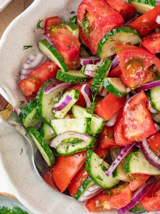 summer salad in a white bowl with a spoon.