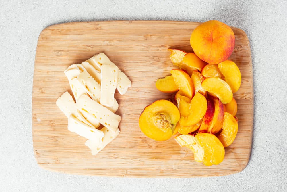 peaches-and-brie-cheese-on-a-wooden-cutting-board-sliced
