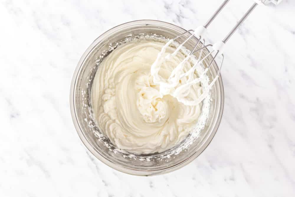 whipping-cream-in-a-silver-bowl-with-hand-mixer