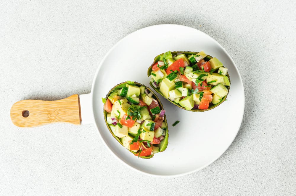 avocado-salad-in-avocado-shells-on-a-white-plate-with-a-handle