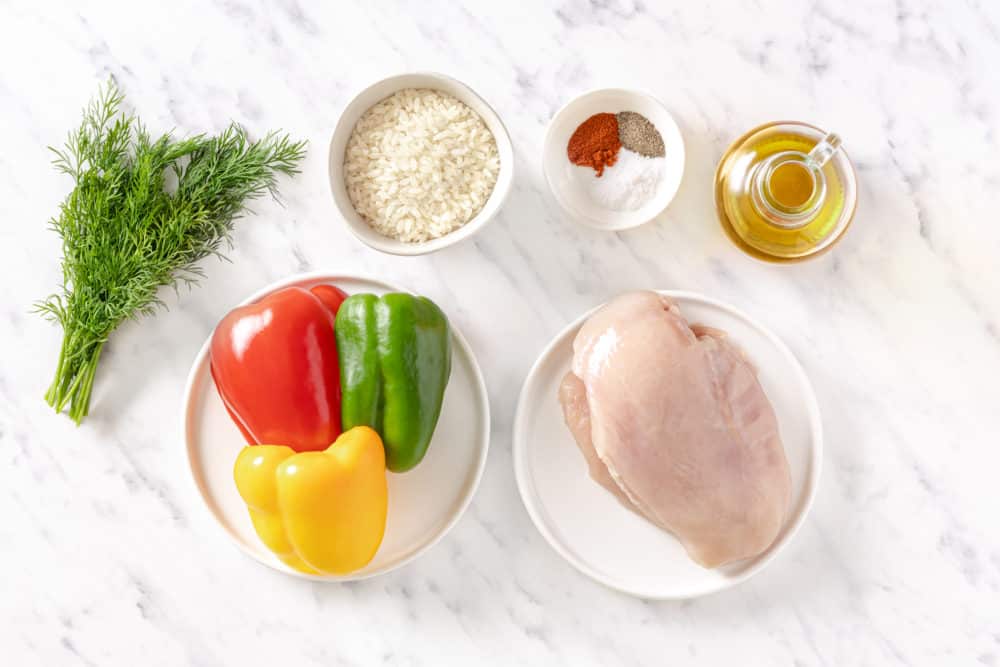 rice bowl ingredients spread raw chicken bell peppers rice salt pepper paprika dill and olive oil.