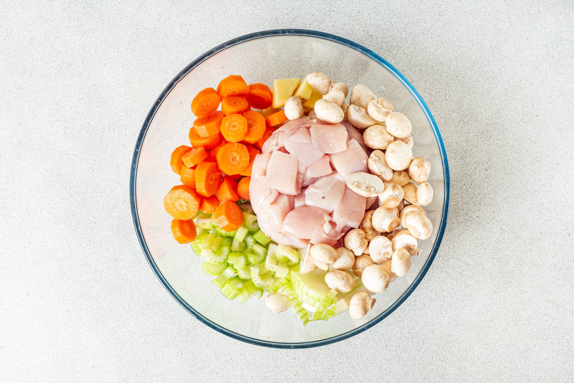 vegetables-and-raw-chicken-chopped-in-a-glass-bowl
