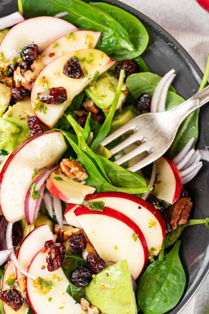 apple-spinach-avocado-salad-on-a-black-plate-with-a-fork