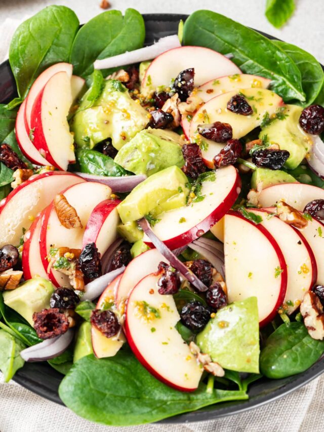 A bowl of apple, spinach, avocado salad.