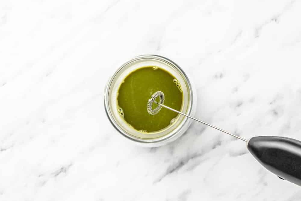 matcha-and-water-being-whisked-with-a-milk-frother