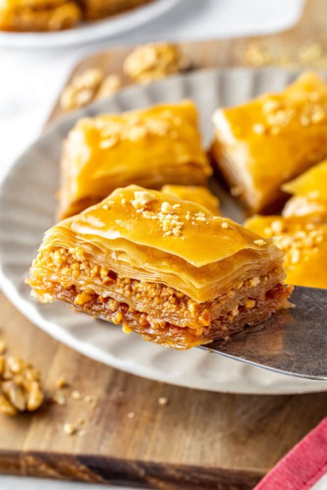 a slice of baklava on a spatula with all the layers revealed.