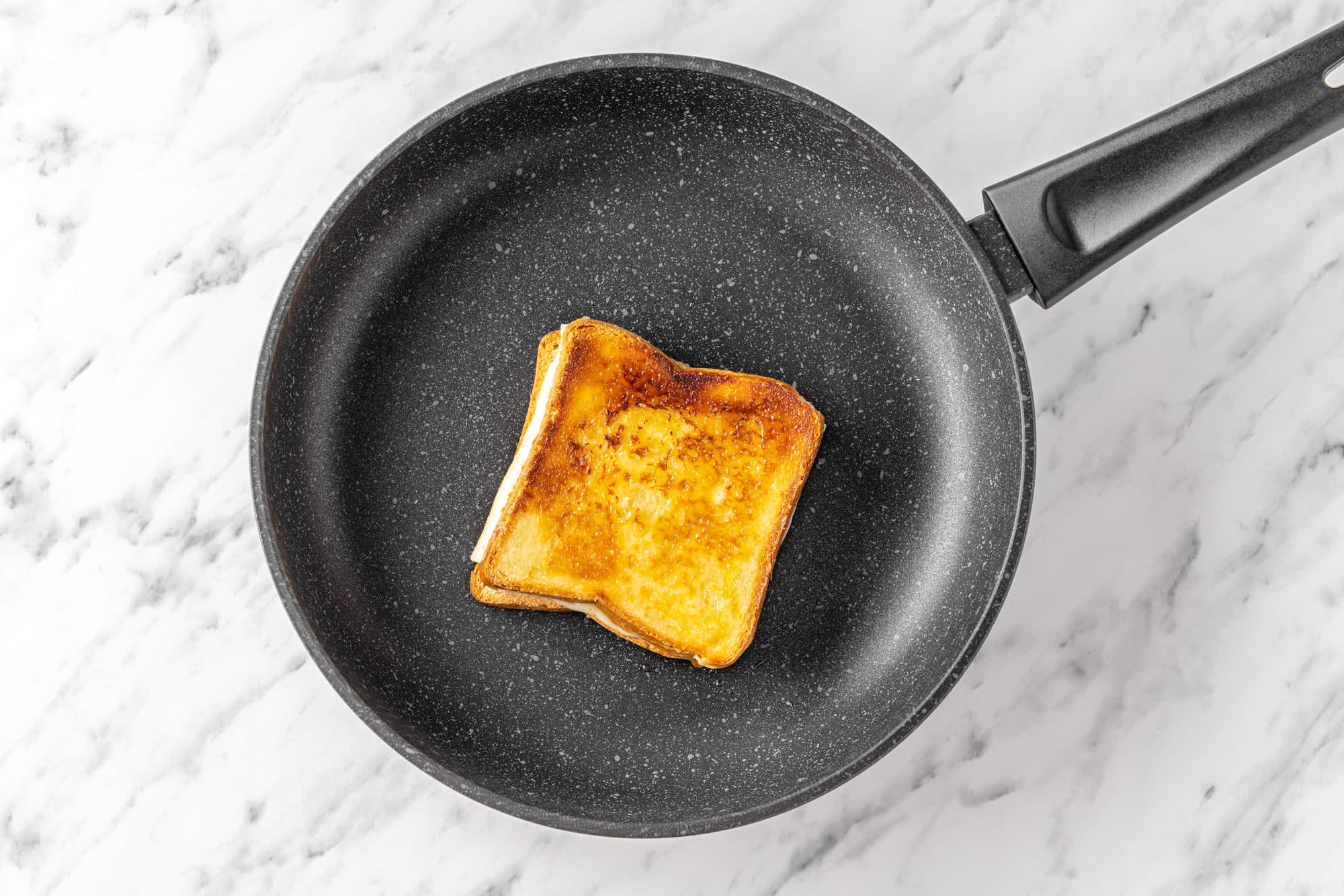 grilled cheese sandwich on a black skillet.