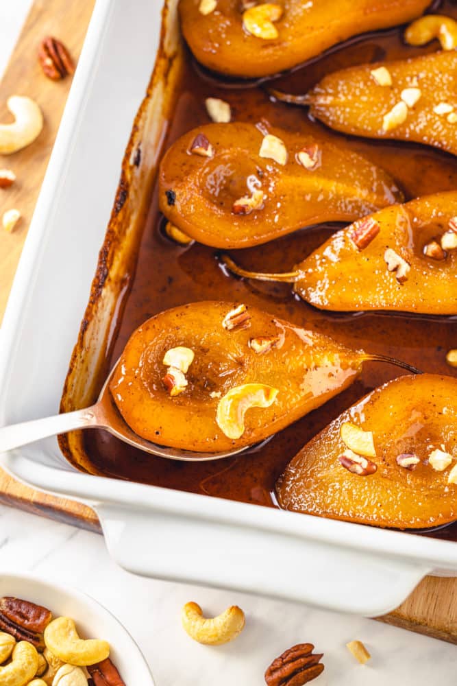 baked and roasted pears in a tray and on a spoon.