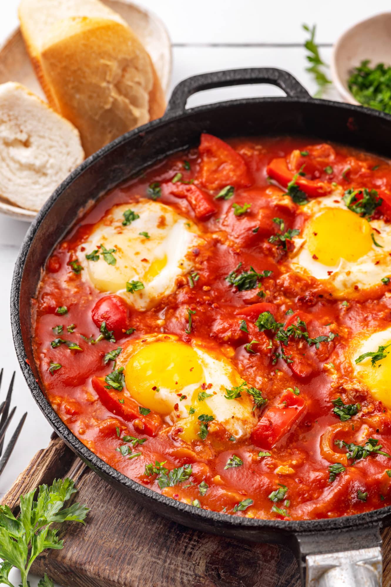 shakshuka-in-a-skillet-on-a-wooden-board-with-bread-on-the-side