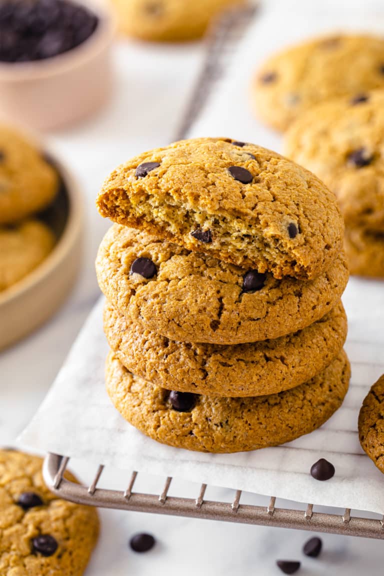 chocolate-chip-cookies-stacked-on-parchment-paper-on-a-cooling-rack