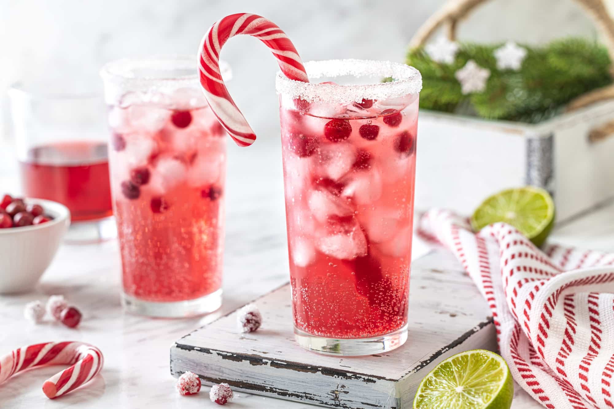 peppermint mocktail drink in a glass with a candy cane in the glass and sugar on the rim.