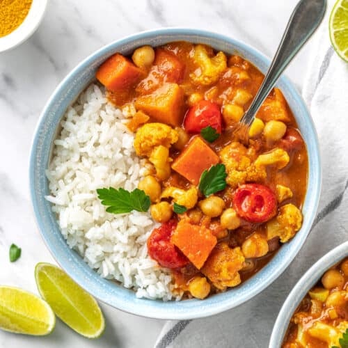 cauliflower and chickpea curry in a bowl with rice.